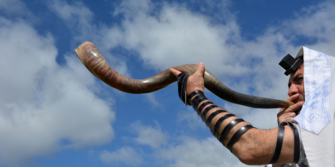上图:一位犹太人在犹太新年吹角节(Rosh Hashanah)吹响羊角。「祂从祸坑里,从淤泥中,把我拉上来,使我的脚立在磐石上,使我脚步稳当」(诗四十2),是犹太人在吹角节期间的Amidah祷告词中的一部分。